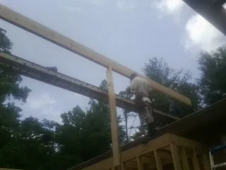 Carpenter setting a ridge beam over a new addition frame — Ice Dam Removal by Roofing Brothers in Sloatsburg