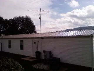 New metal roof on a single wide mobile home with a TV antenna in Sloatsburg