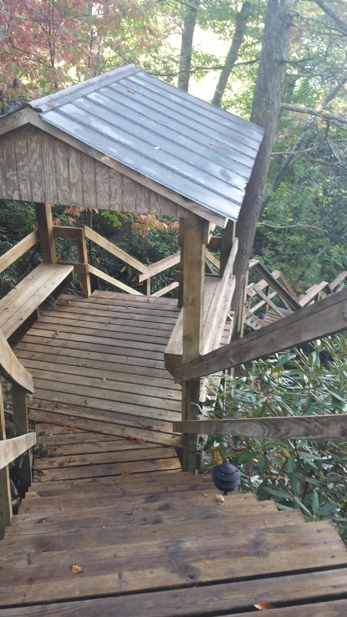 Metal roofed shelter over wooden steps on a wooded walkway — Skylight Repair & Installation work by our crew in Sloatsburg